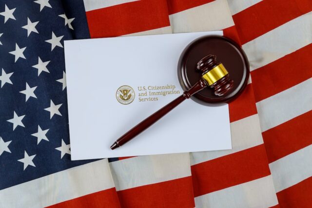 USCIS envelope and gavel on top of an american flag