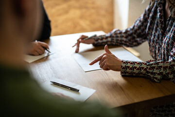 three people at desk with papers