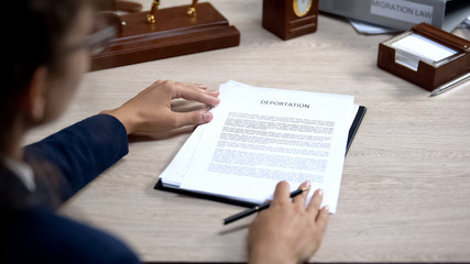 person holding paper that says deportation