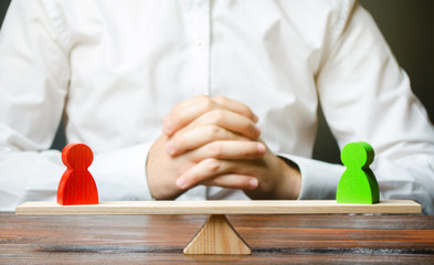 person with balanced scale and mini wooden people
