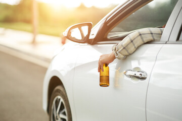 person in car with beer in hand