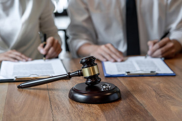 gavel and couple signing papers