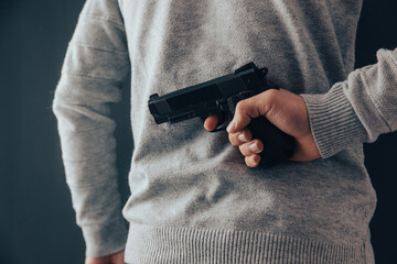 man with concealed gun behind back