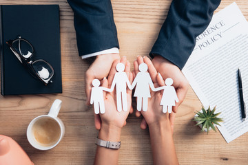 hands holding cutout of family