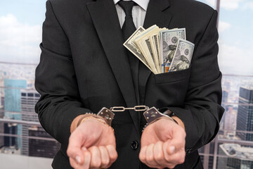 man in suit and handcuffs with money