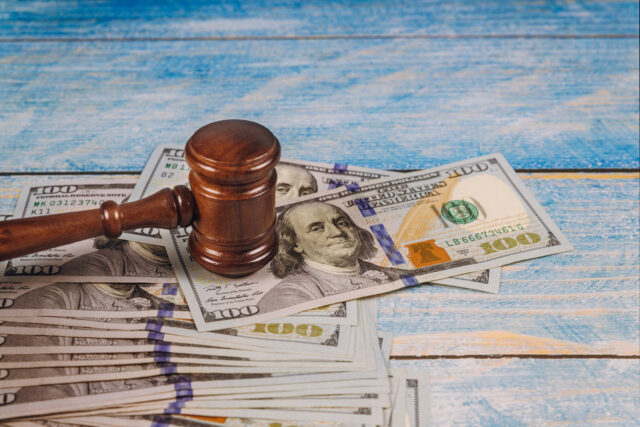 Judge gavel and money on blue wooden table. Court concept.